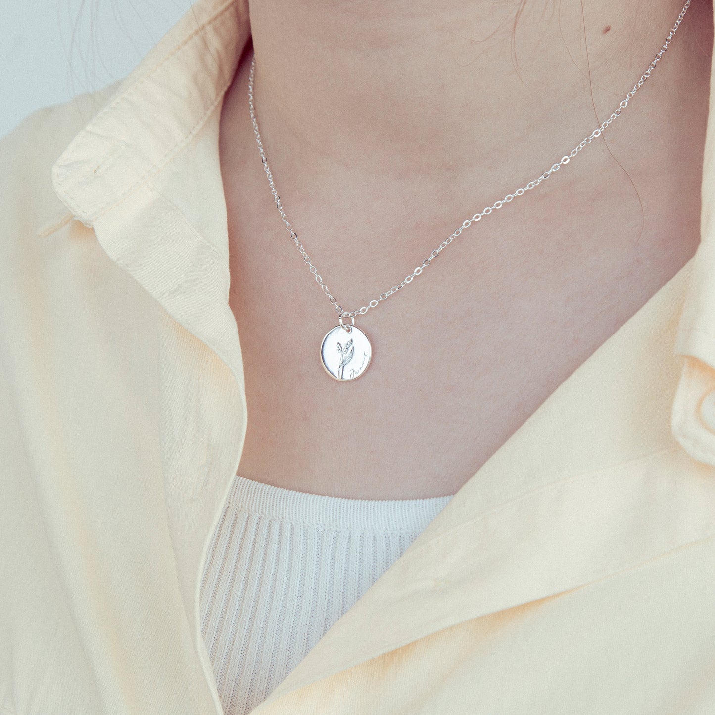 Floral Pendant Necklace on Model: Lifestyle shot of the stainless steel floral pendant necklace worn with a casual outfit, demonstrating its versatility and everyday elegance. (Focuses on lifestyle and usage)