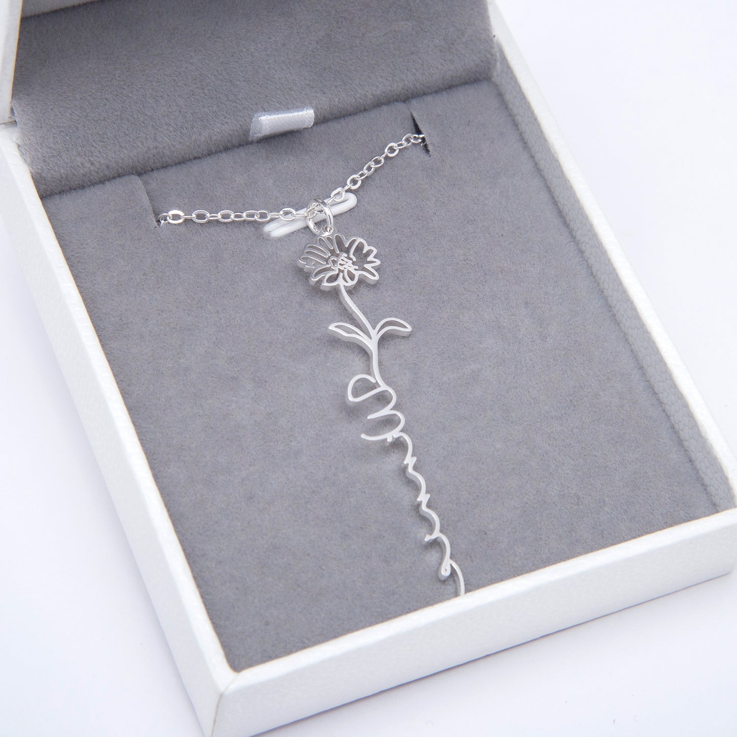 Gift box featuring a personalized Rose birth flower necklace with "Emily" engraved.A thoughtful and personalized gift made of high-quality stainless steel, ready to surprise and delight. (Concentrates on the gift aspect and presentation.)