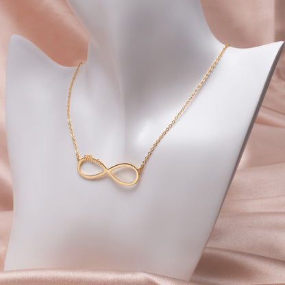 Rose Gold Personalized Infinity Name Necklace in Copper, delicate chain shimmering in soft light. (Highlights a specific color/material variant and adds sensory detail with "shimmering")