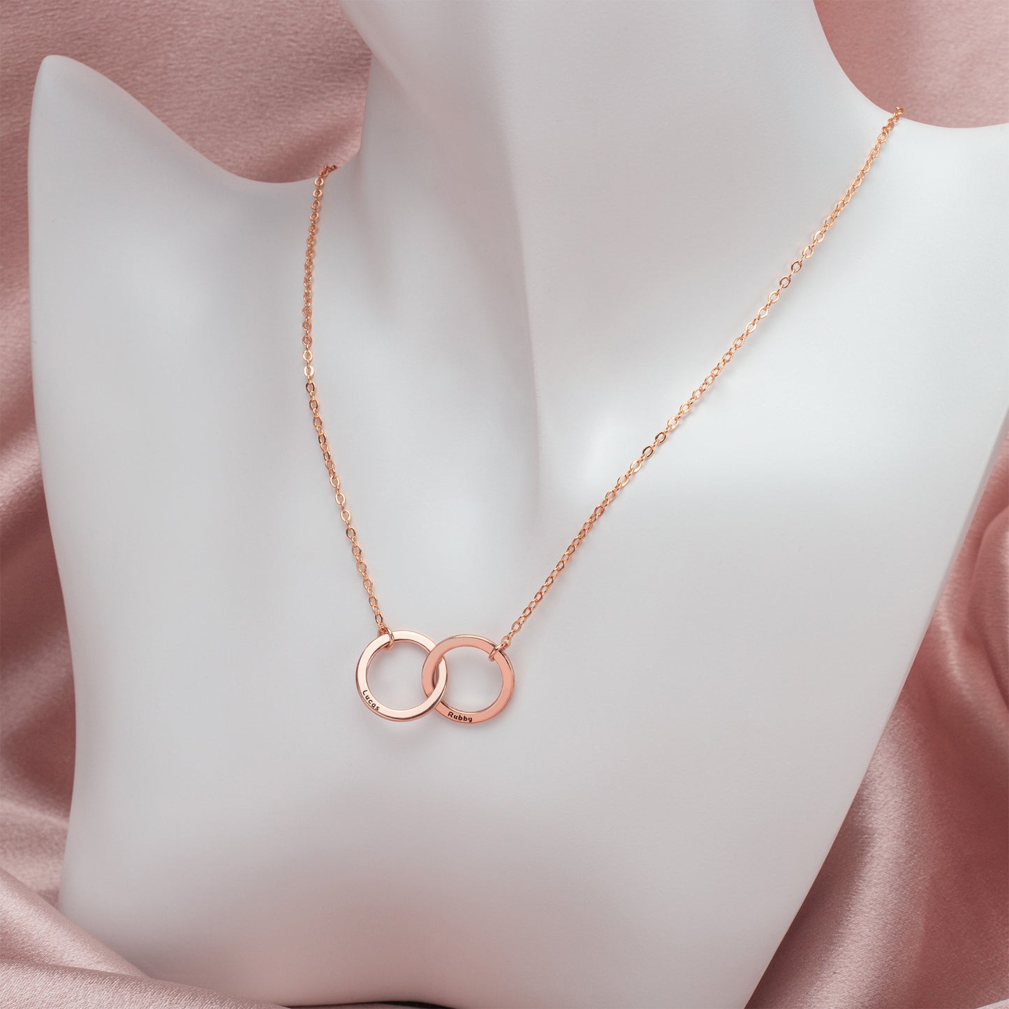 Rose gold interlocking circle necklace on model.Shows the pendant's delicate size and how it lays against the skin. (Highlights color variation "rose gold" – assuming copper plating creates this effect – and emphasizes scale/wearability)