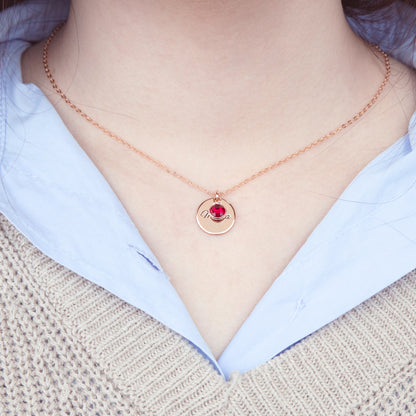 Model wearing a personalized circle birthstone necklace with a [Birthstone Name/Color] birthstone. The stainless steel chain delicately complements the vibrant gem. Arrives in a ready-to-gift box. (Uses lifestyle imagery context and highlights material combination)