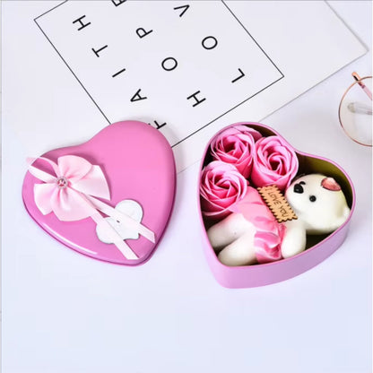 Close-up of three red soap roses in a heart-shaped box.