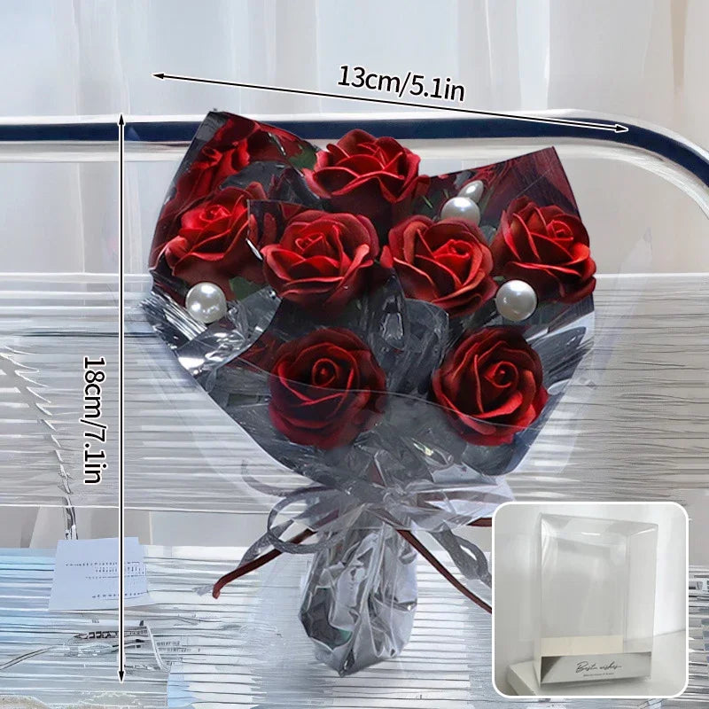 Three red artificial soap roses nestled in a white gift box with a clear lid