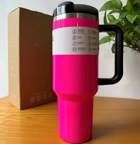 Insulated travel mug with straw, 30oz, green, outdoor setting.