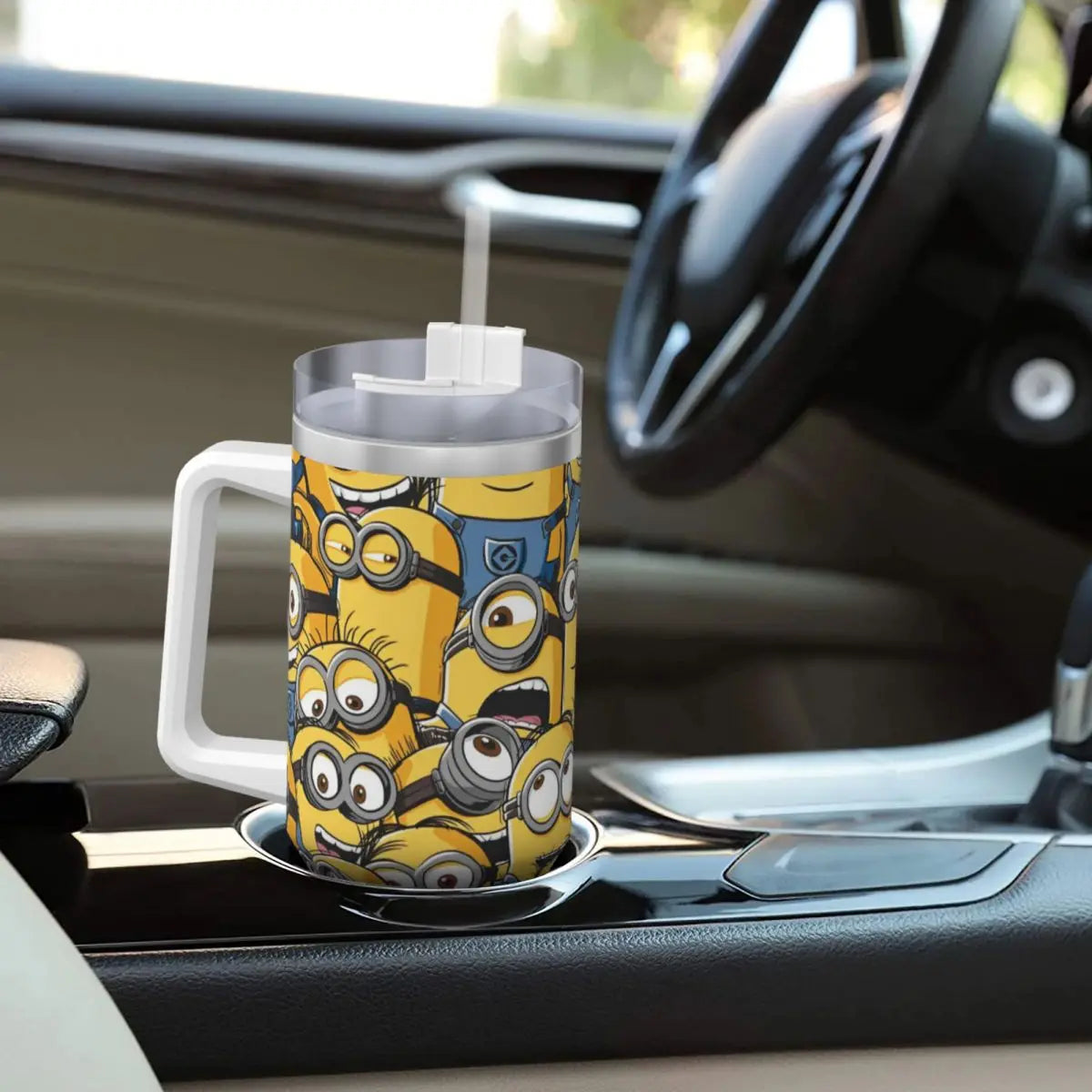 Minions travel mug, held in hand, showcasing size and design, with straw.