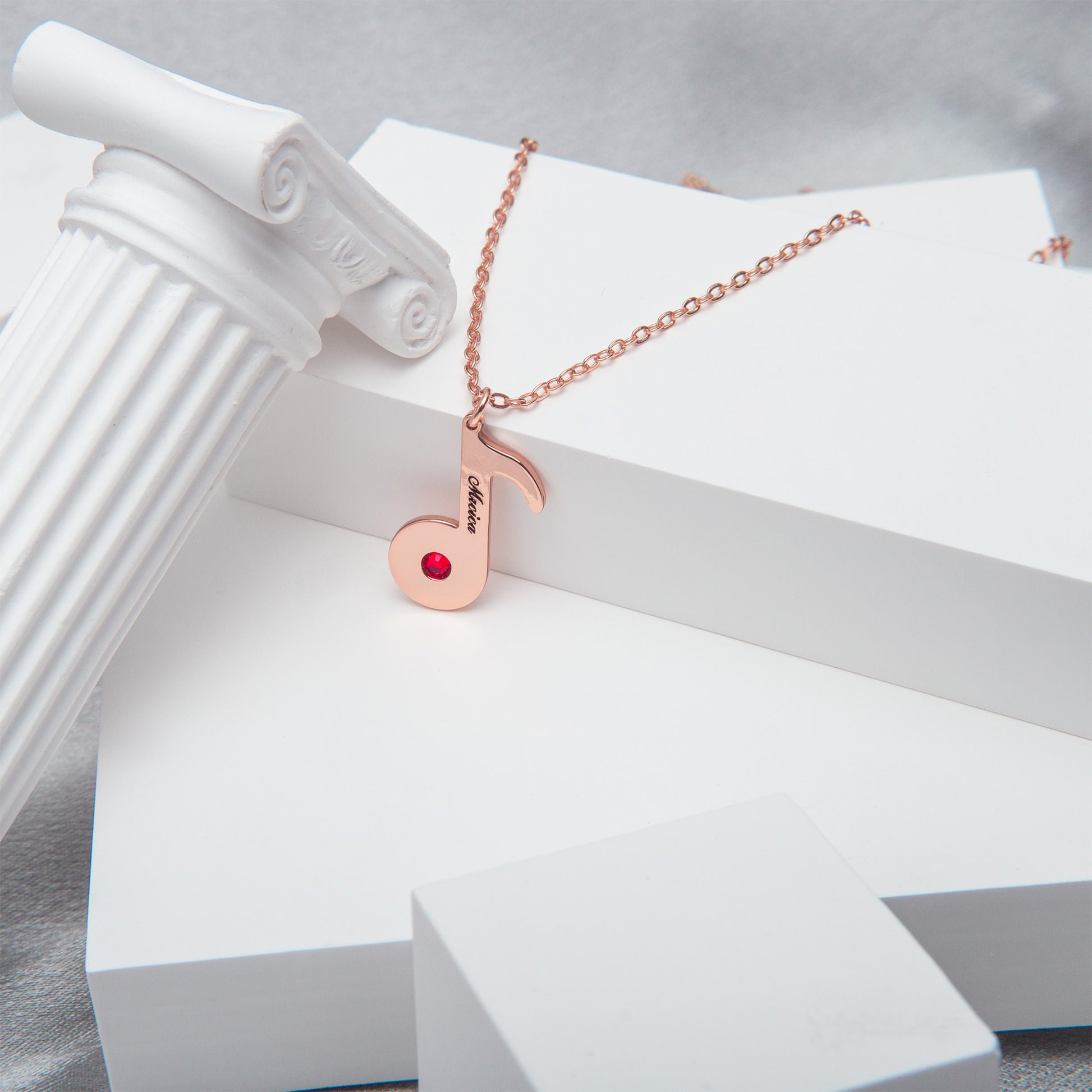 Close-up of a stainless steel music note necklace clasp, highlighting its secure lobster claw design. (Focuses on a specific feature - the clasp)