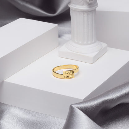 Two personalized stainless steel couple's rings nestled inside a velvet-lined gift box, ready for gifting. (Reinforces the presentation and occasion)