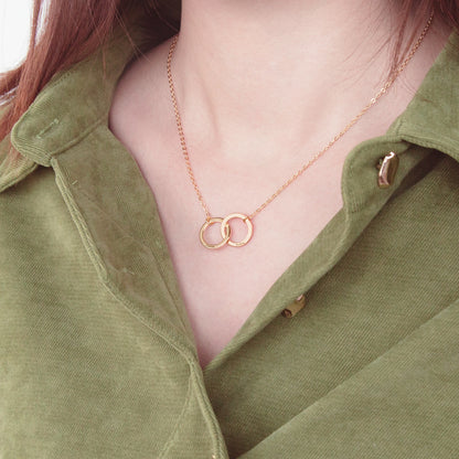 Back view of model wearing the interlocking circle necklace. Demonstrates the adjustable chain length and clasp detail. (Focuses on a practical feature – adjustability – and uses the back view to highlight this)