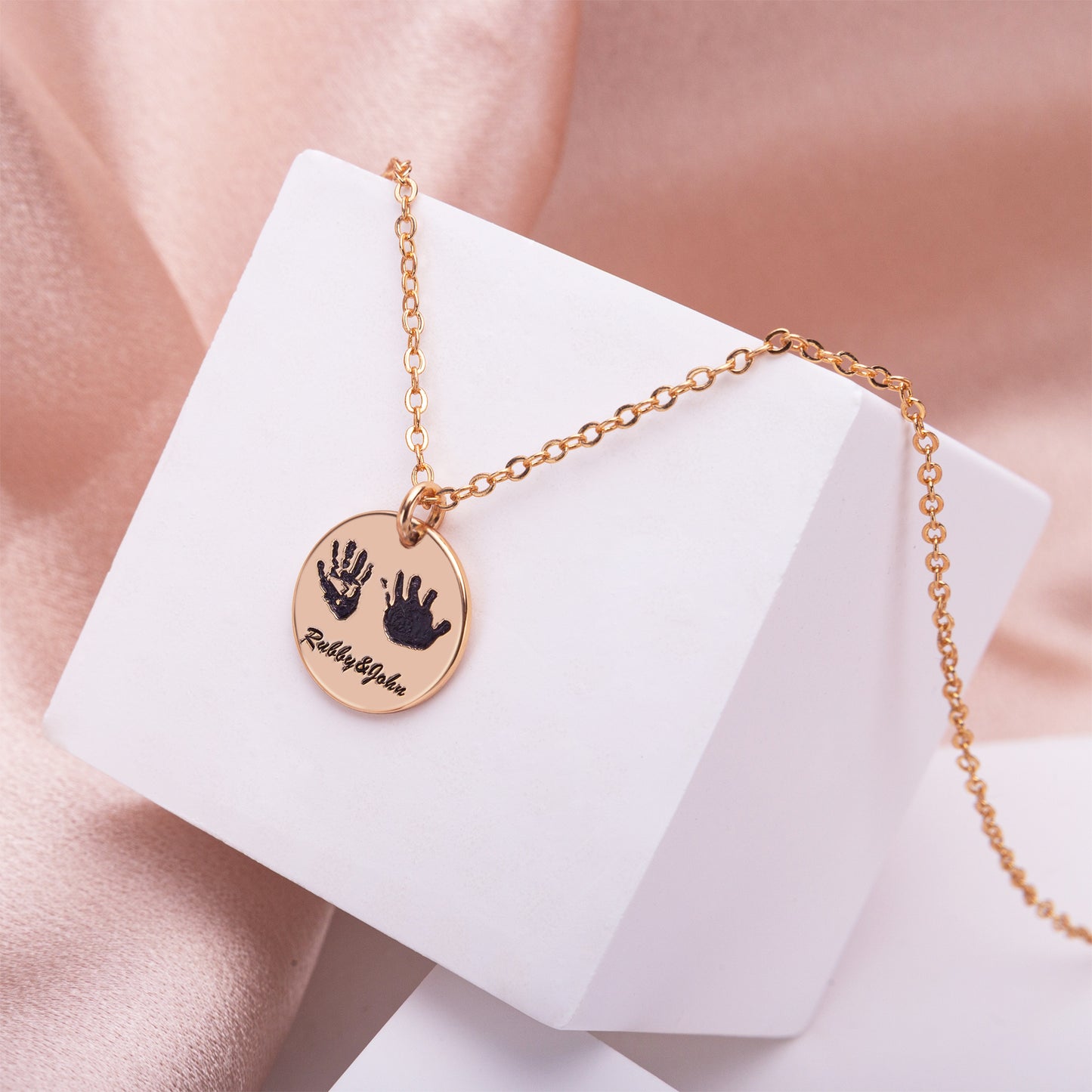 Close-up of a personalized handprint necklace with "Emily" in elegant script on a delicate silver chain, nestled in a satin-lined gift box. Perfect for Mother's Day. (Focuses on detail, occasion, and emotion)